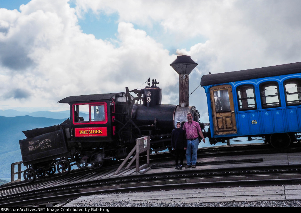 My grandson and I pose beside the smokebox of Mount Washington Cog Railway steam locomotive number 9 - Waumbek during our layover at the summit of the mountain